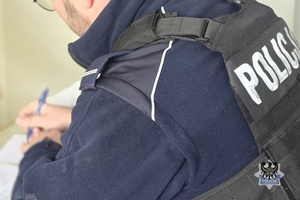 Na zdjęciu policjant sporządza dokumentację.