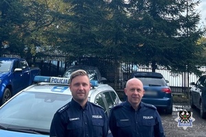 Na zdjęciu policjanci przy radiowozie.