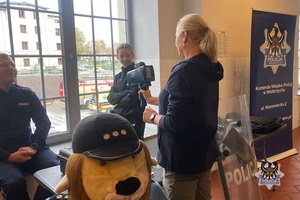 Na zdjęciu policjanta przy stanowisku promocyjnym oraz mieszkańcy.