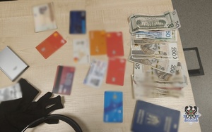 Na zdjęciu zabezpieczone pieniądze, paszport oraz karty płatnicze.