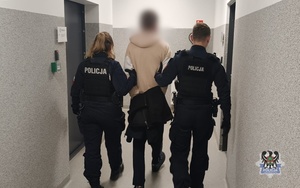 Na zdjęciu policjanci prowadzą zatrzymanego mężczyznę.