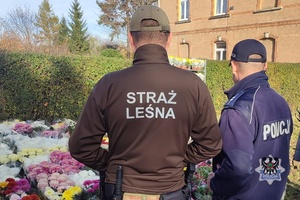 Na zdjęciu policjant i strażnicy leśni w rejonie cmentarzy.