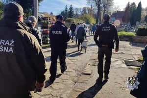 Na zdjęciu policjant i strażnicy leśni w rejonie cmentarzy.