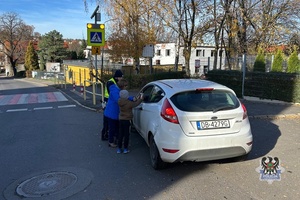 Na zdjęciu policjanci wraz z dziećmi podczas kotnroli drogowej przy szkole.