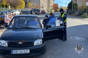 Na zdjęciu policjanci wraz z dziećmi podczas kotnroli drogowej przy szkole.