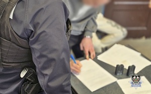 Na zdjęciu policjanci wykonują czynności procesowe z zatrzymanymi mężczyznami.