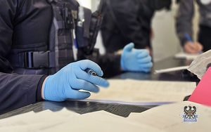 Na zdjęciu policjanci wykonują czynności procesowe z zatrzymanymi mężczyznami.