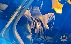 Na zdjęciu zatrzymany mężczyzna wewnątrz radiowozu.