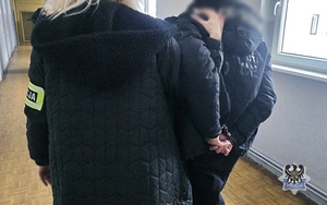 Na zdjęciu policjantka prowadząca zatrzymanego.