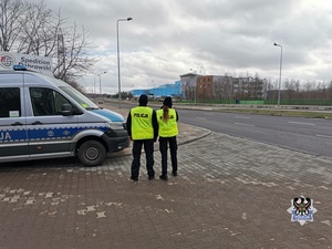 Na zdjęciu policjanci przy radiowozie.