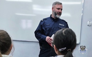 Na zdjęciu policjant w trakcie pogadanki z dziećmi ze szkoły w Jugowicach.