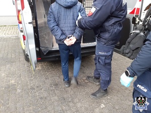 Policjant pilnuje zatrzymanego