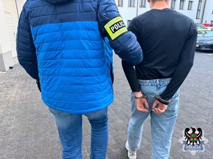 policjant prowadzi zatrzymanego