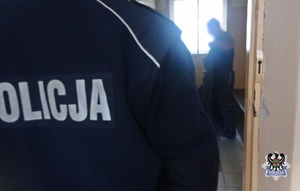 Na zdjęciu policjant umieszcza zatrzymanego w celi.