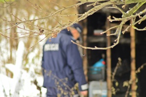 policjant podczas kontroli opuszonych działek, pustostanów