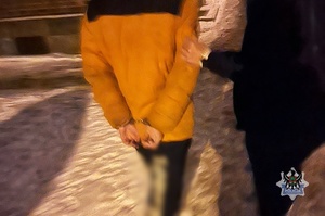 Na zdjęciu policjantka prowadzi zatrzymanego mężczyznę.