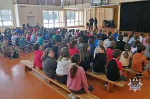 Na zdjęciu policjanci podczas pogadanki z uczniami szkoły podstawowej.