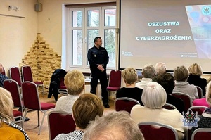 Na zdjęciu policjant w trakcie pogadanki z seniorami.