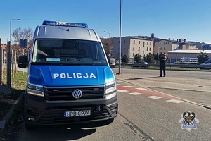 Na zdjęciu radiowóz oraz policjantka.