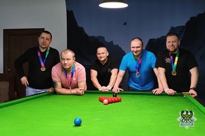Na zdjęciu finaliści turnieju snookera przy stole bilardowym.