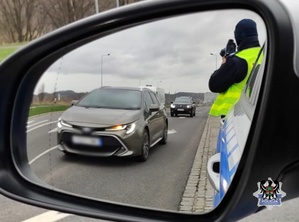 Na zdjęciu policjant w trakcie ręcznego pomiaru prędkości.