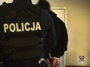 Na zdjeciu policjant prowadzący przykładowego zatrzymanego.