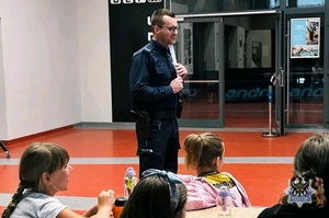 Na zdjęciu policjant podczas pogadanki z uczestnikami spotkania.