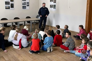 Na zdjęciu policjant w trakcie pogadanki z dziećmi.