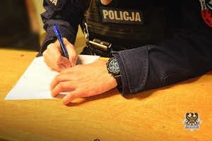 Na zdjęciu policjant sporządza dokumentację.