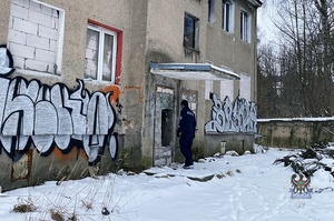 Na zdjęciu policjant w trakcie sprawdzania pustostanu.