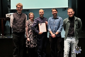 Na zdjęciu policjant z osobami biorącymi udział w pogadance.