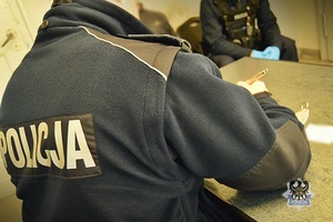 Na zdjęciu policjant sporządzający dokumentację służbową.