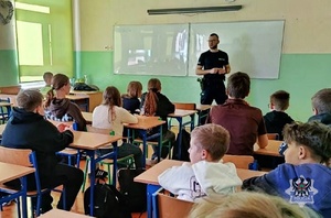 Na zdjęciu policjant w trakcie pogadanki z uczniami.