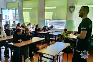 Na zdjęciu policjant w trakcie pogadanki z uczniami.