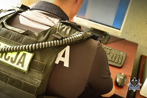 Na zdjęciu policjant wykonujący czynności z zatryzmanym.