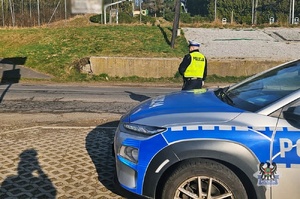 Na zdjęciu policyjny radiowóz oraz policjant.
