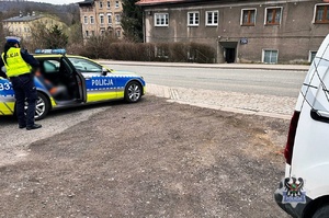 Na zdjęciu policjant i policyjny radiowóz.
