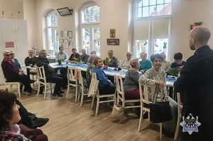 Na zdjęciu policjant w trakcie prelekcji z mieszkańcami Mieroszowa.