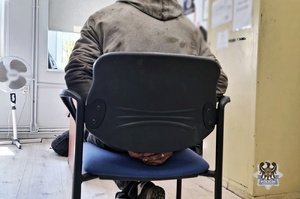 Na zdjęciu mężczyzna zatrzymany siedzi na krześle.