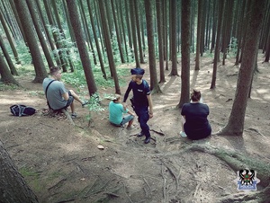 Na zdjęciu policjant na szlaku rozmawia z turystami.