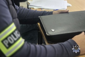 Na zdjęciu policjant w trakcie czynności procesowych.