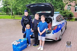 Na zdjęciu policjantka, która przekazuje gry dzieciom.