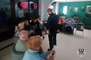 Na zdjęciu policjant rozmawia z seniorami.