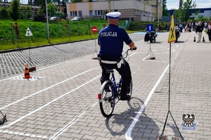 Na zdjęciu policjant demonstrujący zadanie do wykonania przez młodzież.