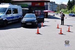 Na zdjęciu radiowóz, kontrowany samochód oraz policjant wykonujący czynności procesowe.
