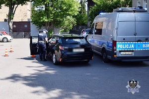 Na zdjęciu radiowóz, kontrowany samochód oraz policjant wykonujący czynności procesowe.