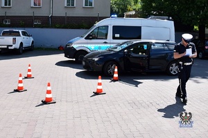 Na zdjęciu radiowóz, kontrowany samochód oraz policjant wykonujący czynności procesowe.