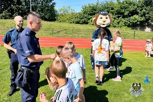 Na zdjęciu policjanci oraz uczestnicy festynu na na stadionie sportowym.
