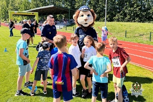 Na zdjęciu policjanci oraz uczestnicy festynu na na stadionie sportowym.