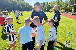Na zdjęciu policjanci oraz uczestnicy festynu na na stadionie sportowym.